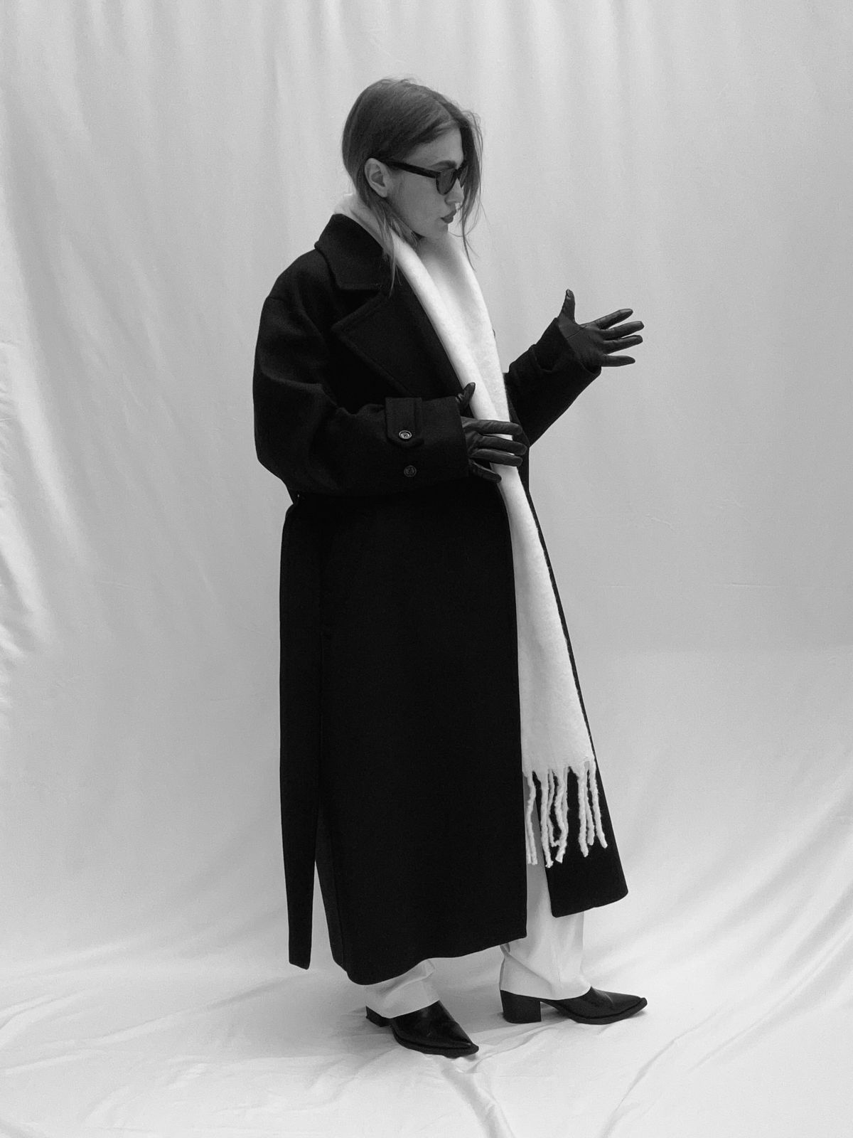Fashion designer Yana Chaplygina in a long black wool coat, white scarf and black leather gloves